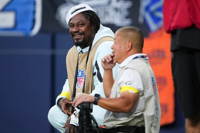 (Video): Marshawn Lynch uses elbow to shield camera from Seahawks running back George Holani during his debut as photographer